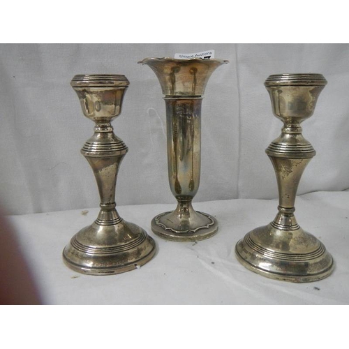 2027 - A pair of silver candlesticks and a silver spill vase.