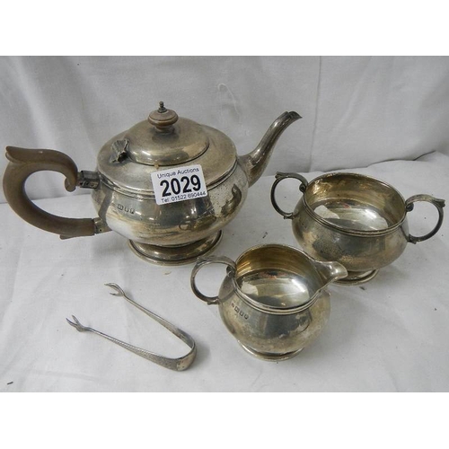 2029 - A 3 piece hall marked silver tea set and sugar nips, 684 grams.