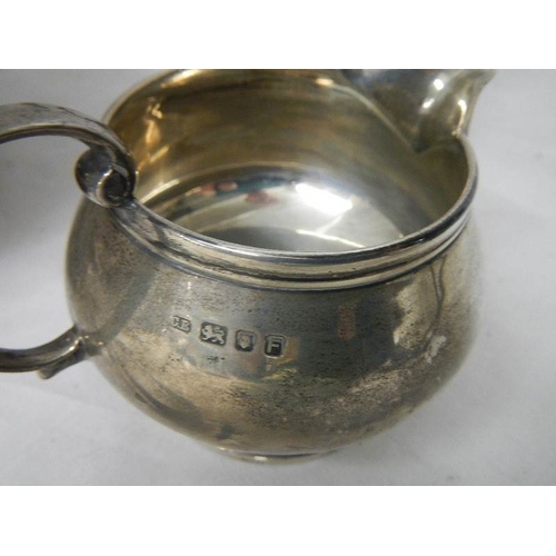 2029 - A 3 piece hall marked silver tea set and sugar nips, 684 grams.