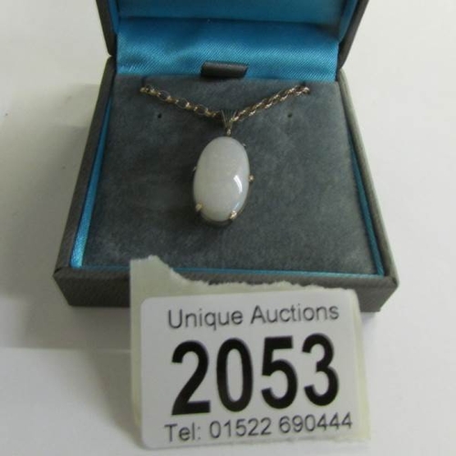 2053 - A circa 1960/70's full opal pendant in an oval shaped gold mount with attached 9ct gold chain.