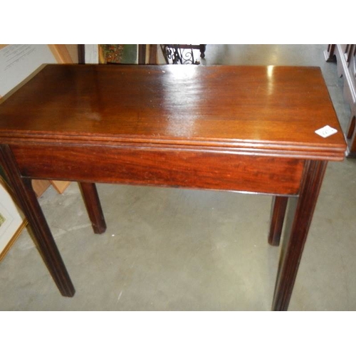 2272 - A fold over card table on square mahogany legs.