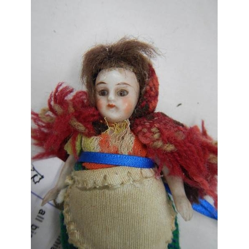 2374 - A miniature porcelain doll, three and three quarter inches tall.