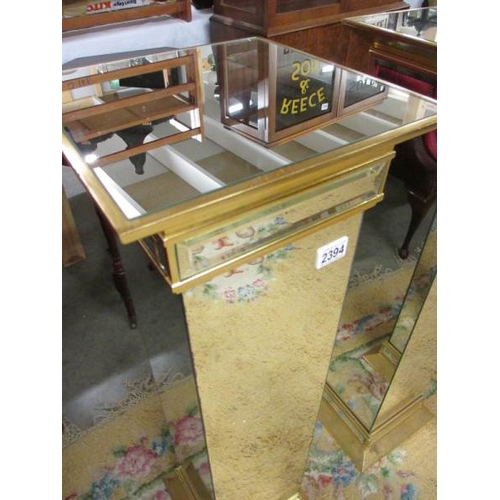 2394 - A pair of bevelled mirrored glass pedestals, 39'' tall.