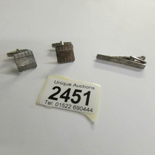 2451 - A pair of silver cuff links and a matching silver tie pin.