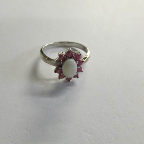 2477 - A Ruby and opal ring in silver in a cluster style, size P.