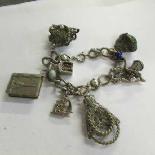 2505 - A Yellow metal pendant, 2 brooches and a charm bracelet.