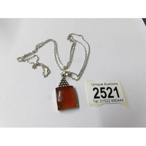 2521 - An amber pendant on silver chain,.