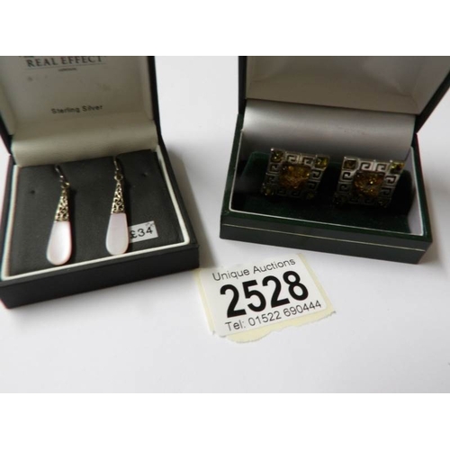 2528 - A pair of silver amber cuff links and a pair of silver pendant earrings.