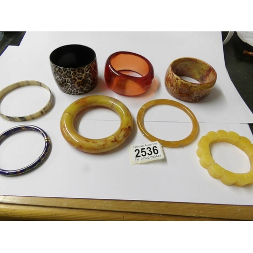 2536 - 8 plastic bangles on stand.