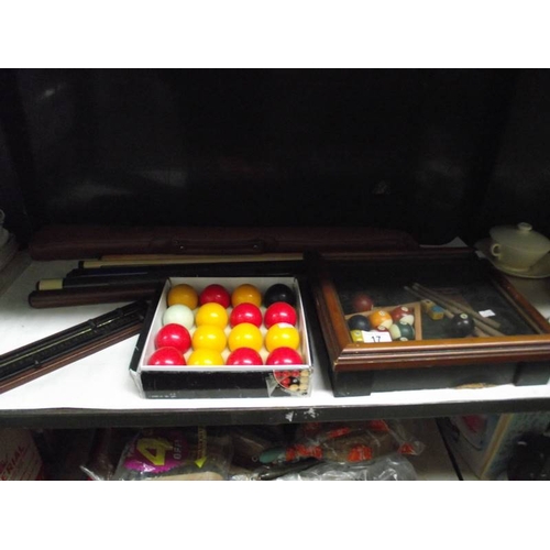 17 - A billiards display cabinet, cues, balls and scoreboard.