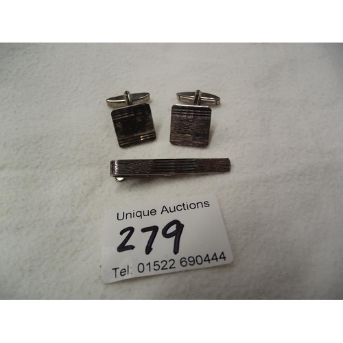 279 - A pair of silver cufflinks and matching tie-pin