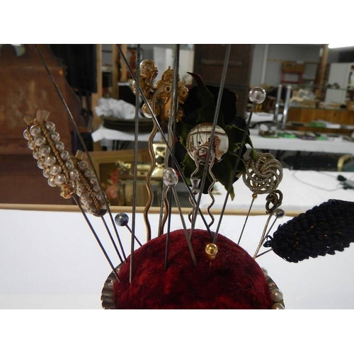 1039 - A hat pin stand with assortment of hat pins.