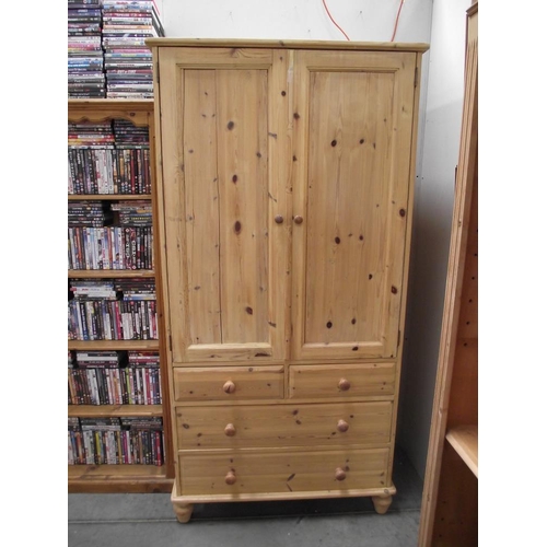 296 - A pine double wardrobe with 3 drawers in base