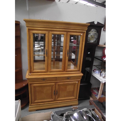 302 - A light wood display cabinet with cupboard base