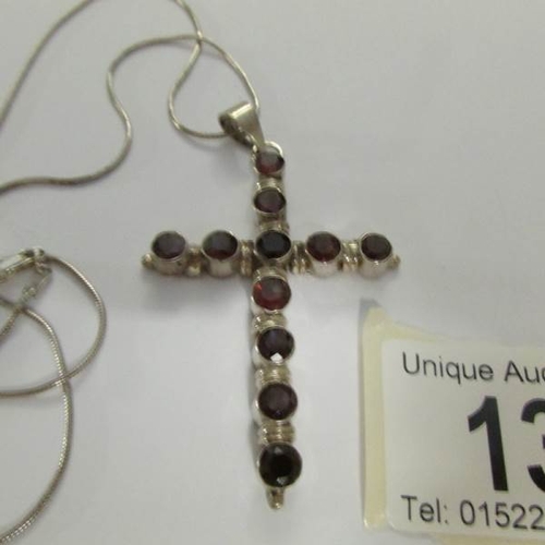 13 - A silver and garnet cross pendant on silver chain.