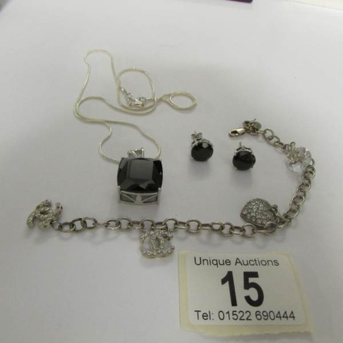 15 - A silver and onyx necklace and earrings together with a silver charm bracelet.