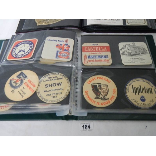 184 - 2 albums of whisky labels and mid 20th century beer mats.