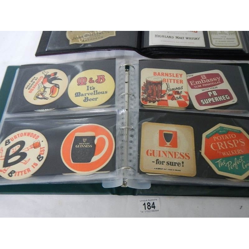 184 - 2 albums of whisky labels and mid 20th century beer mats.