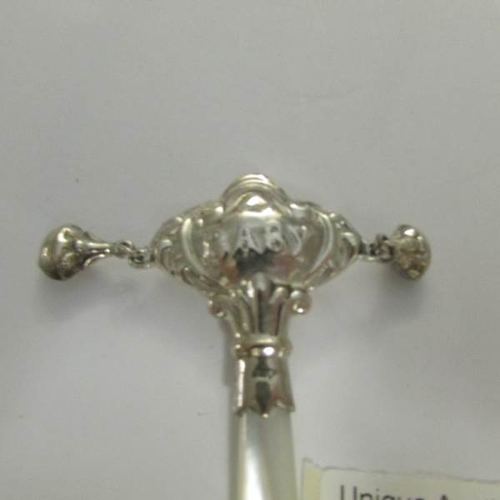 20 - A silver rattle with mother of pearl handle.