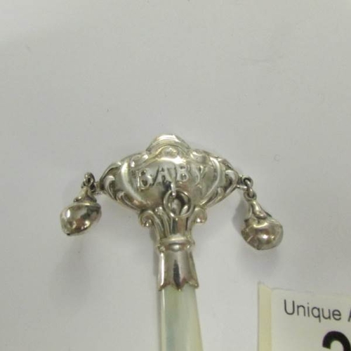 20 - A silver rattle with mother of pearl handle.