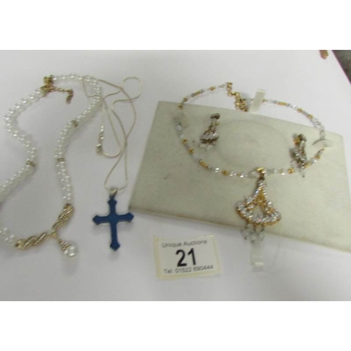 21 - A necklace with matching earrings, a cross on chain and a pearl necklace.