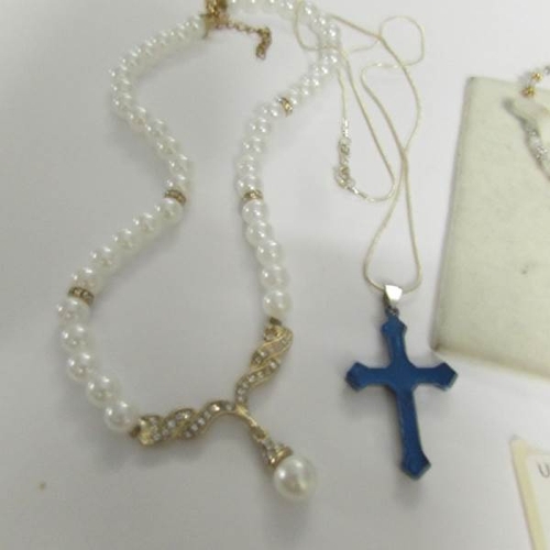 21 - A necklace with matching earrings, a cross on chain and a pearl necklace.