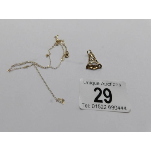 29 - A 9ct gold bell pendant and a finr 9ct gold chain (chain a/f), 1.4 grams.