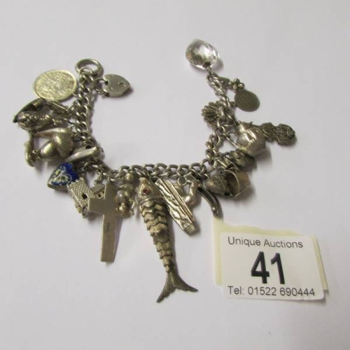 41 - A vintage charm bracelet with a variety of mostly silver charms, some opening, one for Chester, enam... 