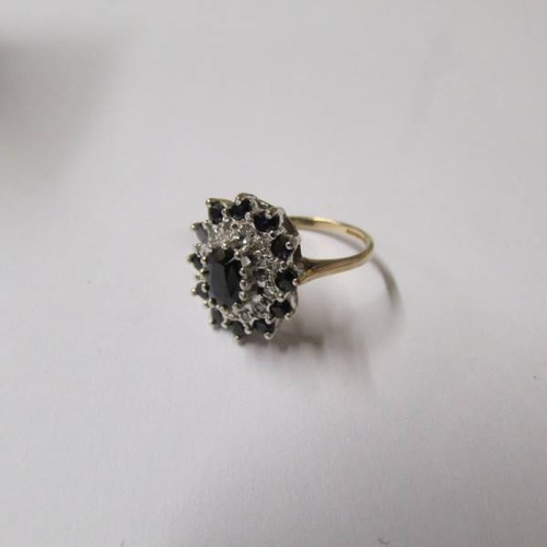 43 - A diamond and sapphire cluster in an oval shaped ring in 9ct gold, dated Birmingham 1987, size K hal... 