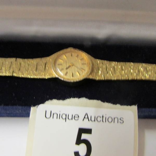 5 - A Longines make ladies watch in textured yellow metal, circa 1970/80's, in working order.