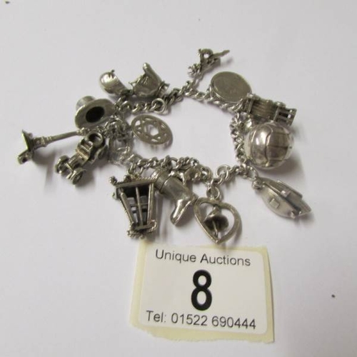 8 - A silver charm bracelet with 15 interesting charms, four open, a boxing glove, vintage car, boat etc... 