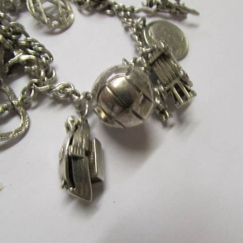 8 - A silver charm bracelet with 15 interesting charms, four open, a boxing glove, vintage car, boat etc... 