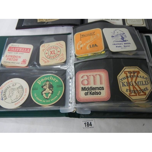 184 - 2 albums of whisky labels and mid 20th century beer mats.