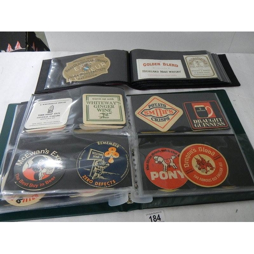 184 - 2 albums of whisky labels and mid 20th century beer mats.