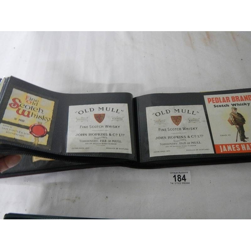 184 - 2 albums of whisky labels and mid 20th century beer mats.