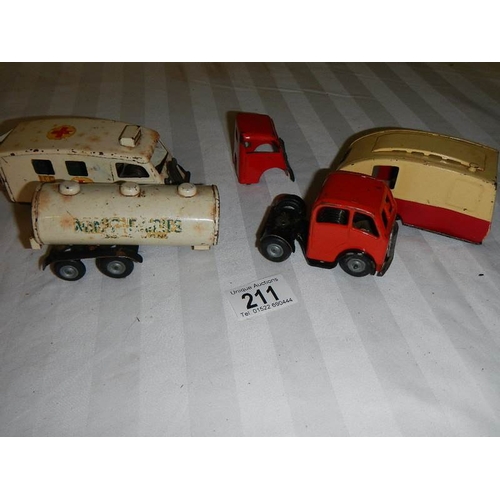 211 - A Triang Minic tinplate clockwork ambulance, a milk tanker and a caravan.