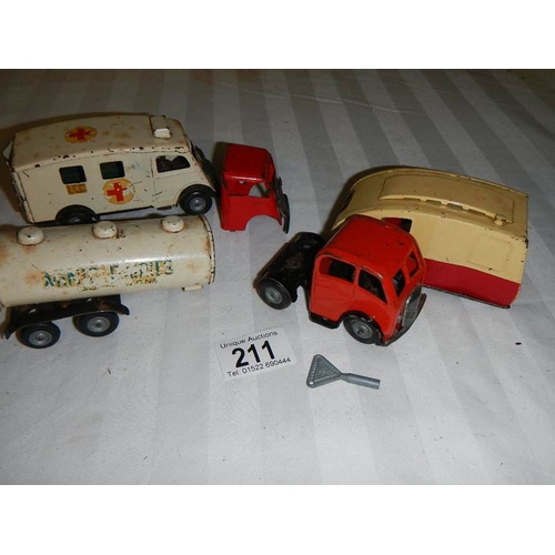 211 - A Triang Minic tinplate clockwork ambulance, a milk tanker and a caravan.