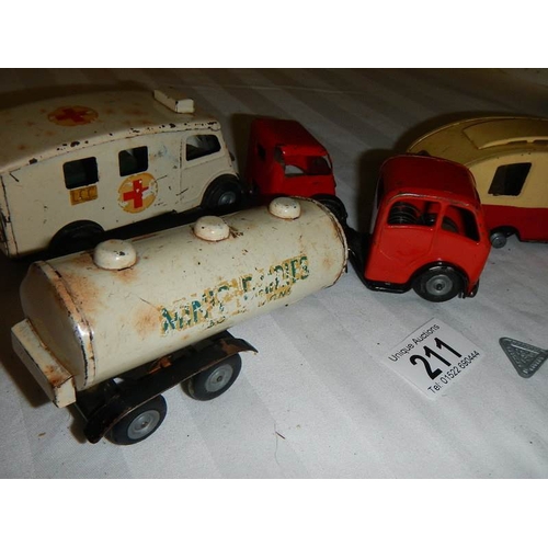 211 - A Triang Minic tinplate clockwork ambulance, a milk tanker and a caravan.