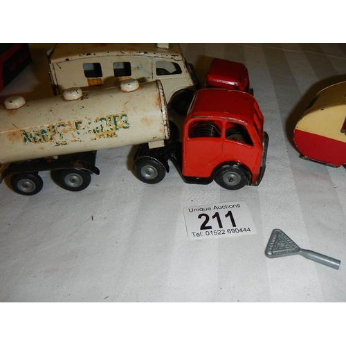 211 - A Triang Minic tinplate clockwork ambulance, a milk tanker and a caravan.