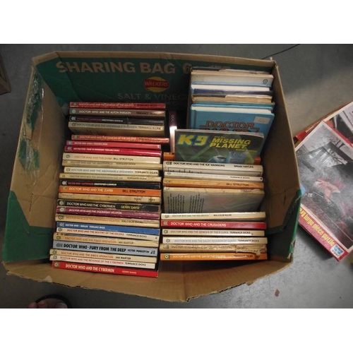 302 - 4 boxes of Doctor Who books. jigsaws, magazines etc.,