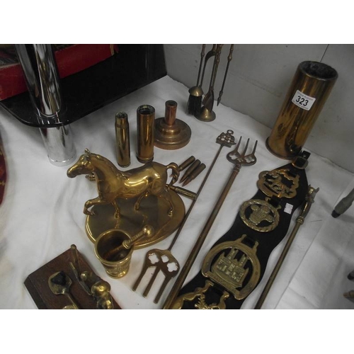 323 - A mixed lot of brass ware including shell cases, toasting forks, horse etc.,