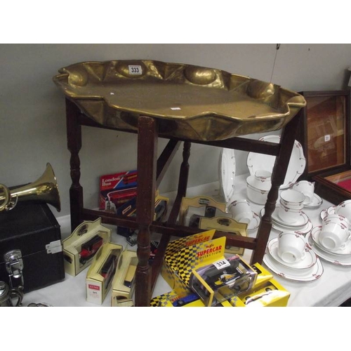 333 - An Eastern brass tray table with folding base.