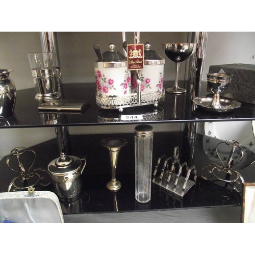 344 - 4 shelves of assorted chrome and silver plate including cutlery, tray, condiment sets etc.,