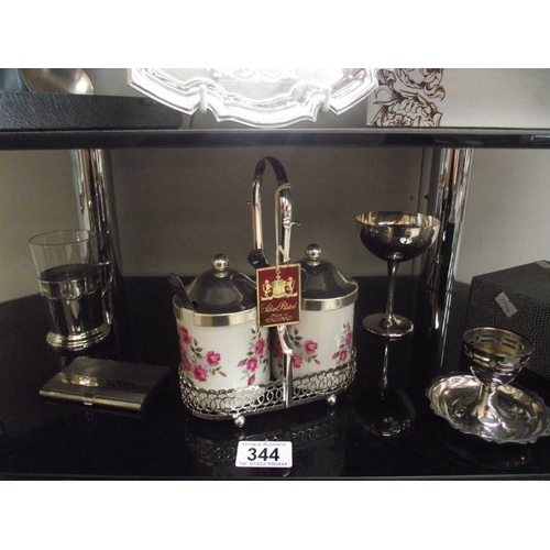 344 - 4 shelves of assorted chrome and silver plate including cutlery, tray, condiment sets etc.,