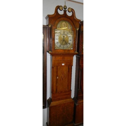 653 - An oak long case clock, 8 day, arched dial with sun motif.