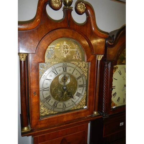 653 - An oak long case clock, 8 day, arched dial with sun motif.