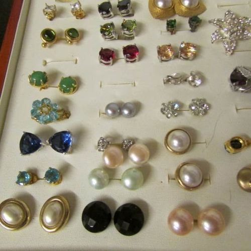 68 - A case containing approximately 34 pairs of earrings including turquoise and pearl.