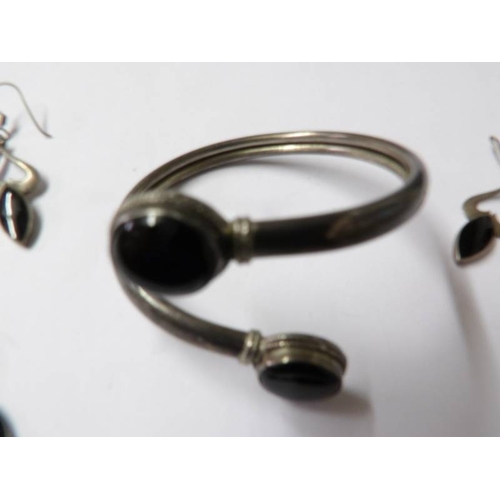 87 - A silver and onyx bangle, bracelet and earrings.