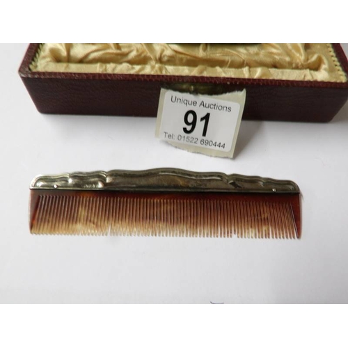 91 - A cased silver backed hair brush and comb.