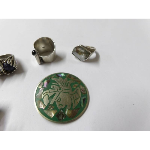 98 - 5 silver rings and a silver brooch.